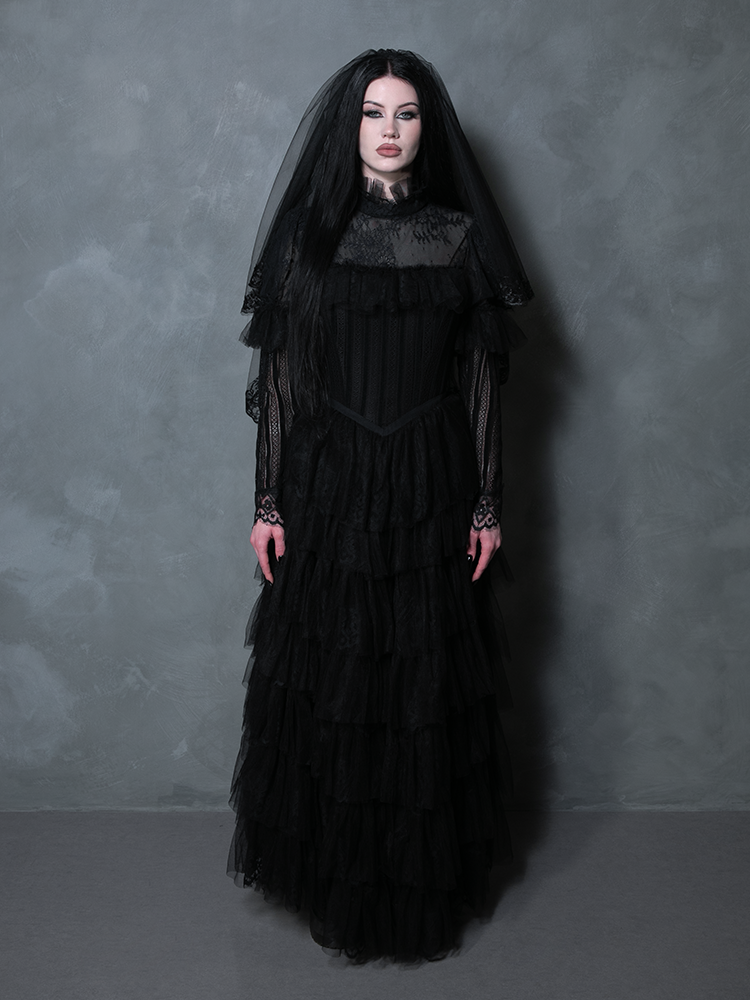 Woman styled in a captivating black romantic gown tailored for the alternative goth bride.