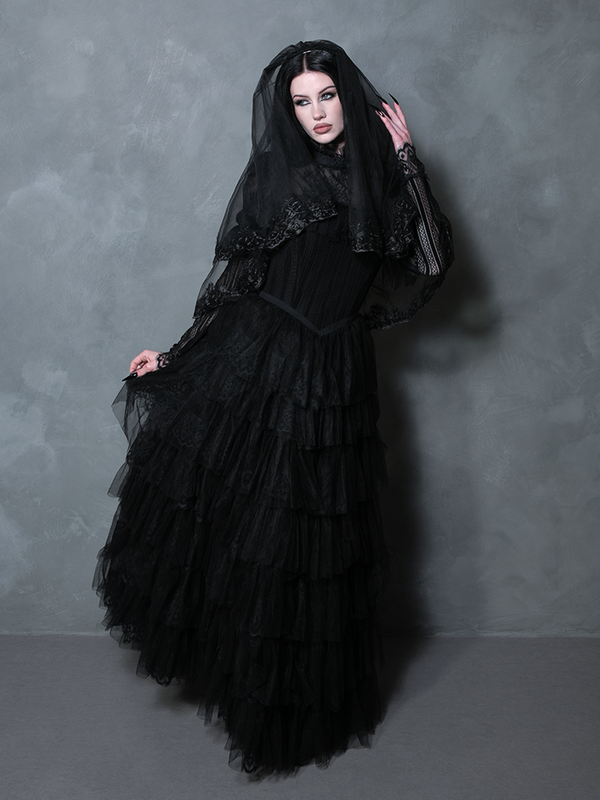 Female model showcasing a luxurious black gown designed for the modern romantic gothic enchantress.