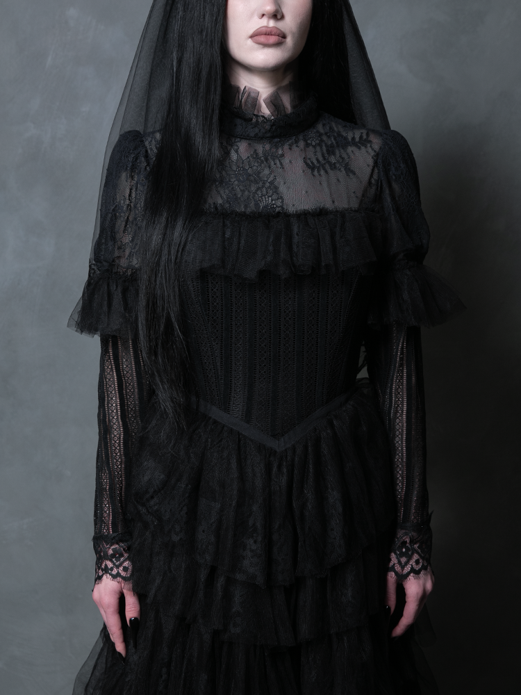 A stunning female model draped in a luxurious black gothic dress channeling elegant vampiric style.