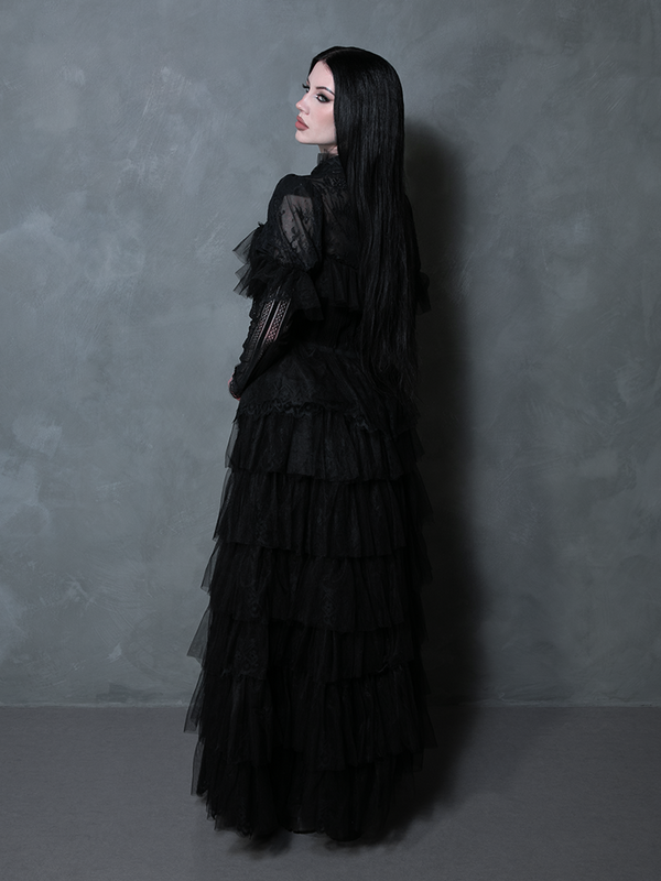 A striking female figure wearing a midnight black ethereal dress perfect for dark formal occasions.