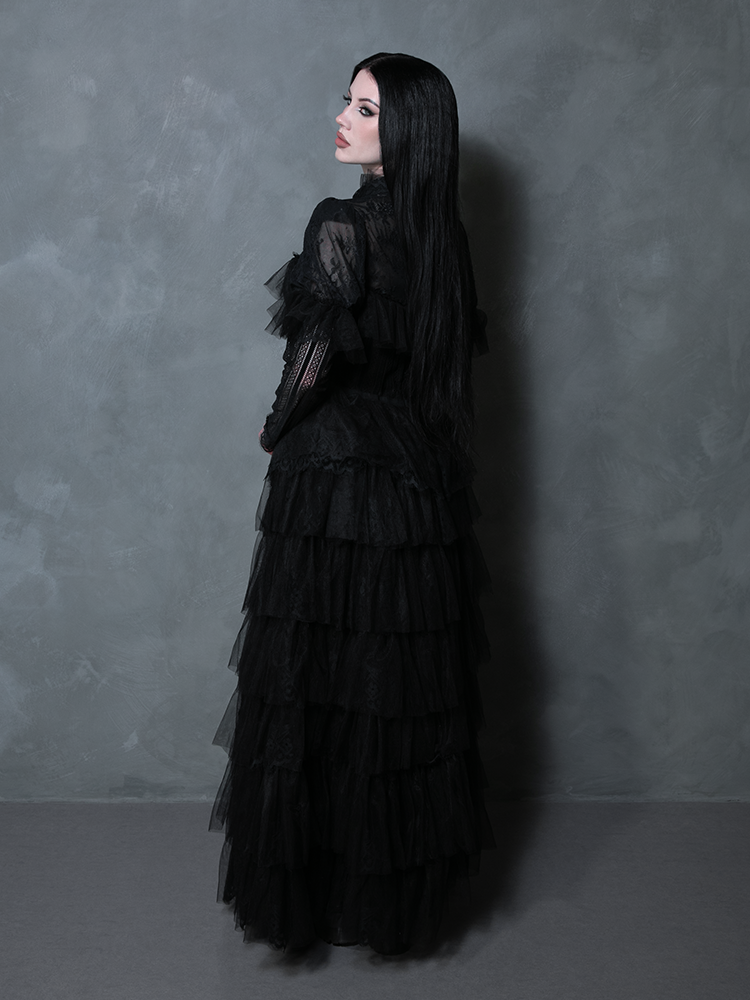 A striking female figure wearing a midnight black ethereal dress perfect for dark formal occasions.