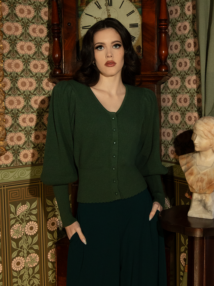 With its high neckline and dramatic sleeves, this hunter green cardigan evokes the elegance of a bygone era, perfect for layering over your favorite gothic pieces.

