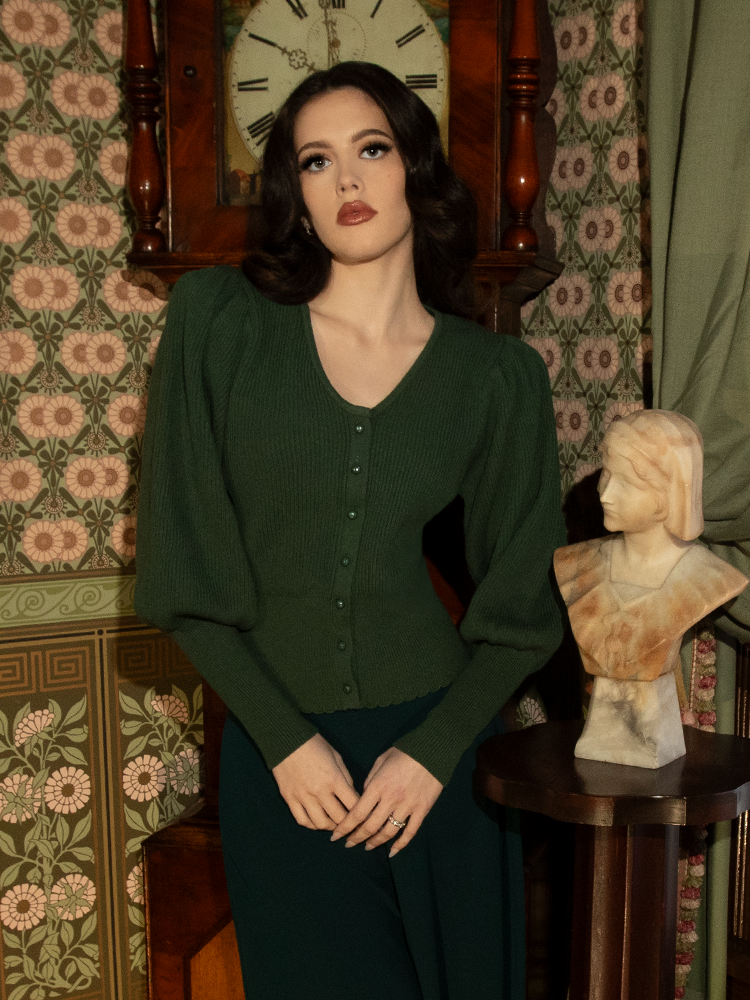 Luxuriously soft yet exquisitely structured, this hunter green knit cardigan is a staple for lovers of Victorian fashion, with ornate button details and timeless charm.

