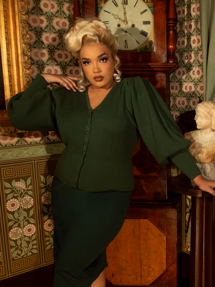 Embrace old-world sophistication with this hunter green cardigan—perfectly structured with delicate lace trim, statement buttons, and gracefully gathered sleeves.

