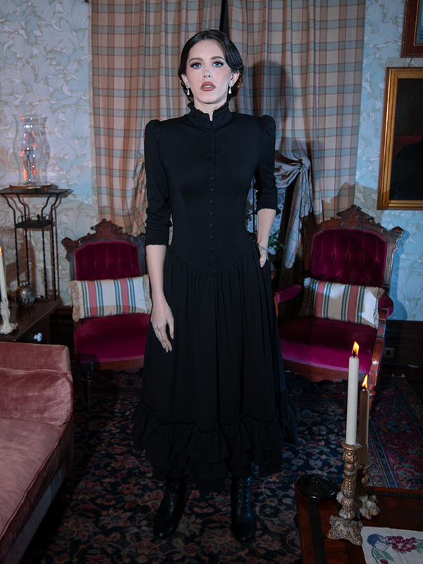 Infused with Whimsigoth enchantment and gothic glamour, a female model steps out in a breathtaking black Victorian dress.