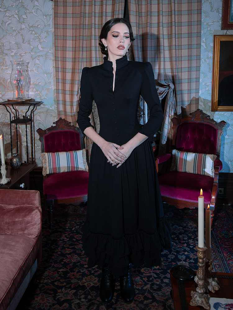Capturing a spirit of dark romance and dark elegance, a female model wears a luxurious black gothic clothing masterpiece.