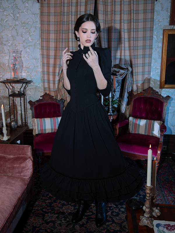Steeped in Victorian Goth allure and dark elegance, a female model brings a hauntingly romantic black dress to life.