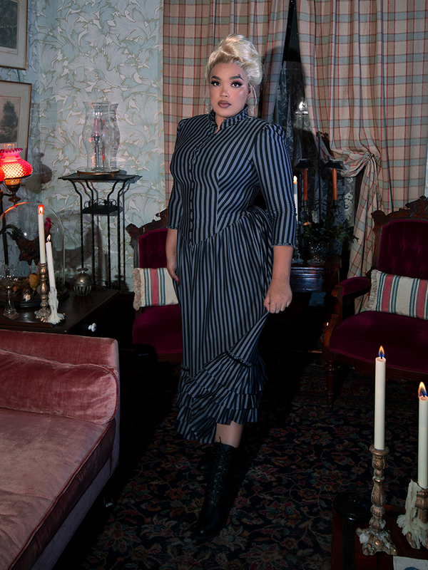 The Victorian Dress in Black and Gray Stripes exudes gothic elegance with its dramatic high neckline, structured bodice, and flowing skirt, capturing the essence of vintage sophistication.