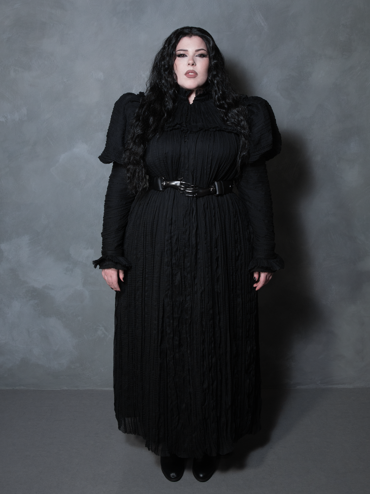 A female model presents an aura of dark elegance and poetic melancholy while wearing an ornate black gothic dress.