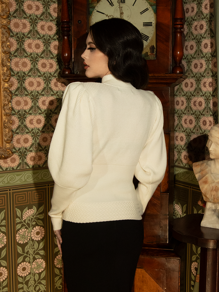 Evoking Victorian sophistication, this ivory pullover’s high neckline, pleated sleeves, and soft, breathable knit make it a statement of classic beauty.

