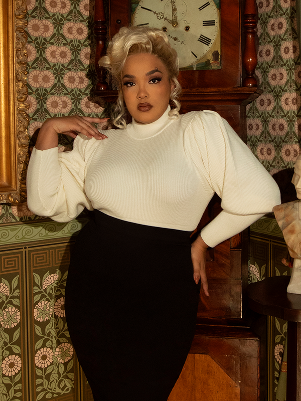 The essence of romantic adventure, this ivory cycling sweater boasts a high collar, pleated sleeves, and a tailored fit—ideal for gothic dreamers on the move.

