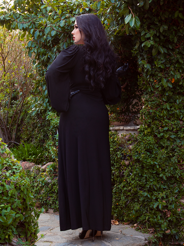 Model styled in the solid black Black Widow Wrap Gown, exuding luxurious occult charm and majestic midnight fashion.