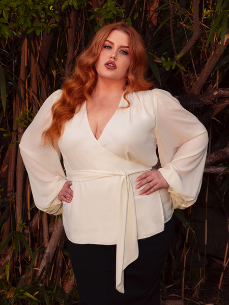 Envelop yourself in the spectral beauty of the Georgette Wrap Top in Ivory. Its gossamer georgette fabric drapes effortlessly, casting an aura of mystery and grace. Perfect for both twilight gatherings and sunlit strolls, it exudes a timeless gothic allure.