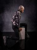 Side profile shot of Braxton Holmes in the  Alien™ Xenomorph Bomber Jacket on top off black jeans and black vinyl boots..