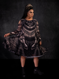 Jyoti Kaur holding out the skirt on the Alien™ Xenomorph Trapeze Dress to reveal the intricate and iconic design.