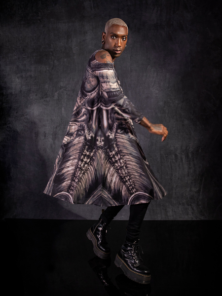 Braxton Holmes wearing the Alien™ Xenomorph Trapeze Dress caught midspin showing off a profile view of the design on the Alien™ Xenomorph Trapeze Dress.