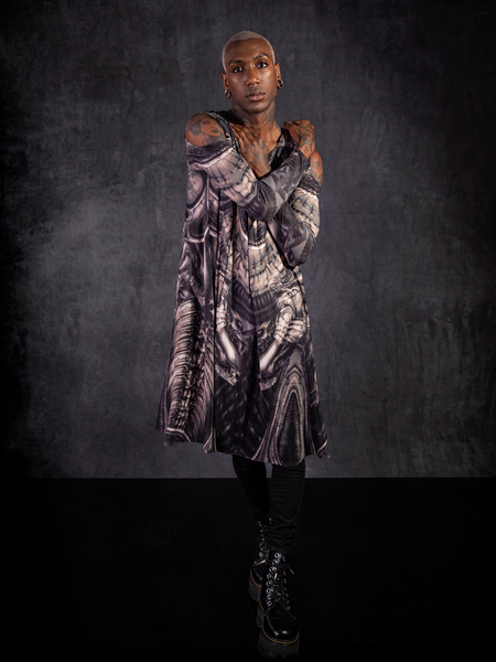 Braxton Holmes posing with his arm crossed across his chest to show off his gothic outfit including the Alien™ Xenomorph Trapeze Dress.