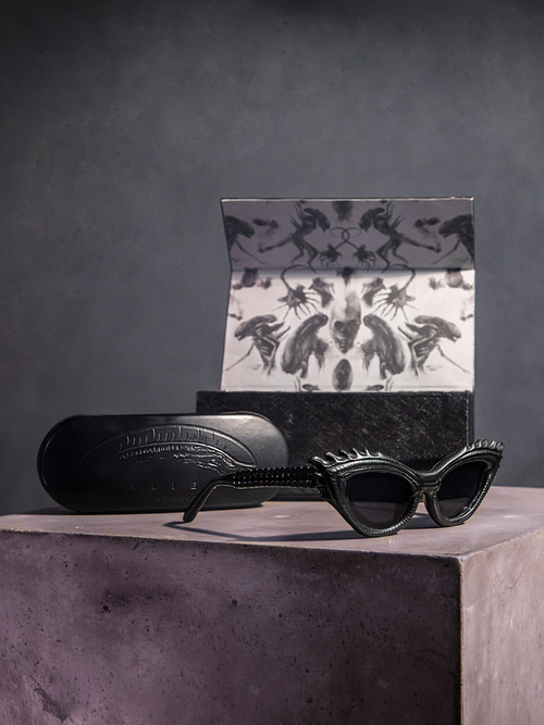 Product shot of the Alien™ Xenomorph Cat-Eye Sunglasses along with unique carrying case and product box.