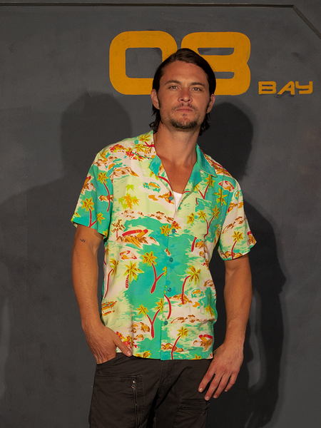 Model poses with one hand tucked into his front pocket while wearing the ALIEN Space Souvenir Button Up Shirt.