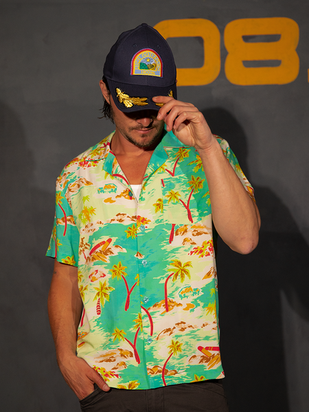 Shiloh tucks one hand into his front pocket and pulls the brim of his hat down while wearing the ALIEN Space Souvenir Button Up Shirt.