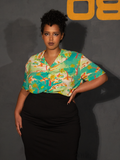 Model with her hand on her hip wears the ALIEN Space Souvenir Button Up Shirt paired with a black skirt.