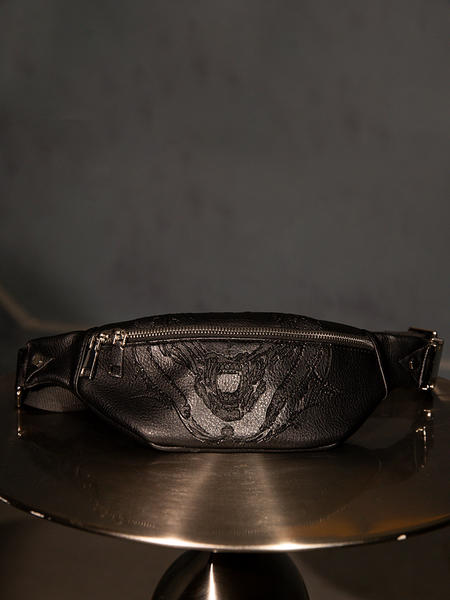 Isolated product shot of the ALIEN Xenomorph Hip Bag on a metal table.