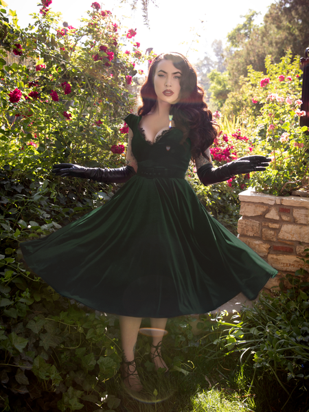 Micheline Pitt twirls around in the Baudelaire Swing Dress in Hunter Green showing off the gorgeous and luxurious fabric.