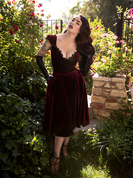 Leaning her head to the side, Micheline Pitt's hair flows into the Baudelaire Swing Dress in Oxblood.