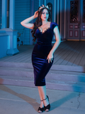 Full length image of Ashley posing in the Baudelaire Wiggle Dress in Midnight Blue from goth dress company La Femme en Noir.