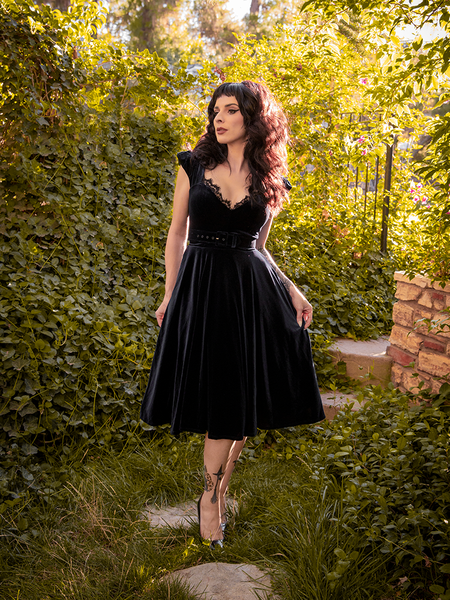Stephanie pulling out on the sides of the skirt to show off the all-new Baudelaire Swing Dress in Black.