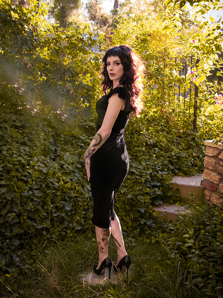 Profile shot of Stephanie  wearing the Baudelaire Wiggle Dress in Black from goth clothing company La Femme en Noir.