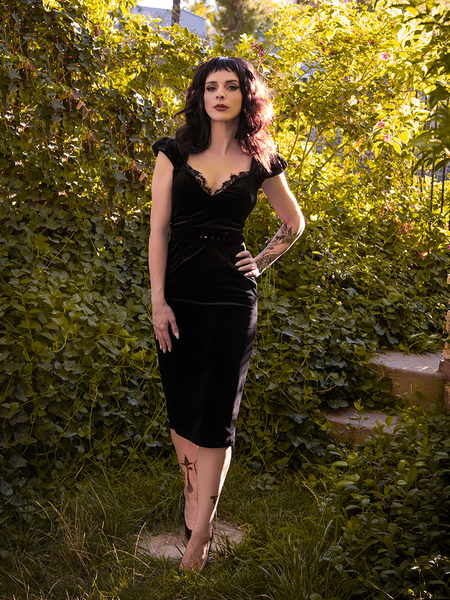 Striking a post with one hand on her hip, Stephanie wears the sexy Baudelaire Wiggle Dress in Black. 