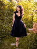 Posing in a luscious garden, Stephanie poses while wearing the Baudelaire Swing Dress in Midnight Blue.