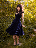 Full body shot of Stephanie modeling the Baudelaire Swing Dress in Midnight Blue from goth clothing company La Femme en Noir.