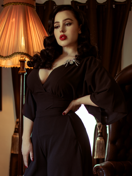 Rachel stands in a beautiful home with her hand on her hip modeling the Bauhaus top in black from La Femme En Noir.