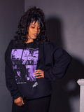 Model with one hand on her hip and the other resting on her thigh, standing while wearing the Ghost Sweatshirt from La Femme en Noir.