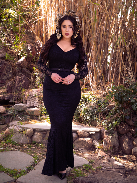 Rachel Sedory wearing the Black Marilyn Lace Gown in Black in front of a bamboo area.