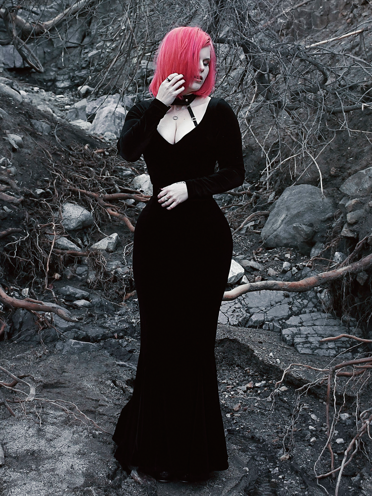 A full length shot of Mackenzie modeling the Black Marilyn gown in black paired with a harness.