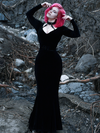 With her hands on her head, Mackenzie models the Black Marilyn gown in black paired with a harness.