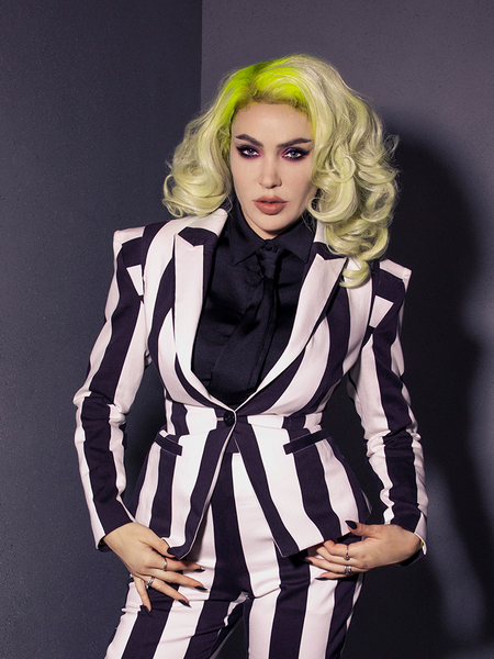 Close-up of Micheline Pitt in a black and white striped jacket and pants combo with the Bowie Blouse w/Matching Tie in Black Charmeuse worn underneath the jacket.