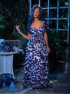 Vanessa gently tugs on the side of her dress to highlight the delicate butterfly print on Tim Burton's CORPSE BRIDE™ Butterfly Maxi Dress in Dusk Blue.