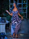 Model delicately posing while the skirt on the Tim Burton's CORPSE BRIDE™ Butterfly Maxi Dress in Dusk Blue flutters in the breeze. 