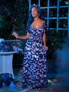 Vanessa modeling Tim Burton's CORPSE BRIDE™ Butterfly Maxi Dress in Dusk Blue as she stands in a smoky, outdoor garden area. 
