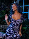 Waist length shot of Vanessa in Tim Burton's CORPSE BRIDE™ Butterfly Maxi Dress in Dusk Blue from gothic glamour clothing brand La Femme en Noir.