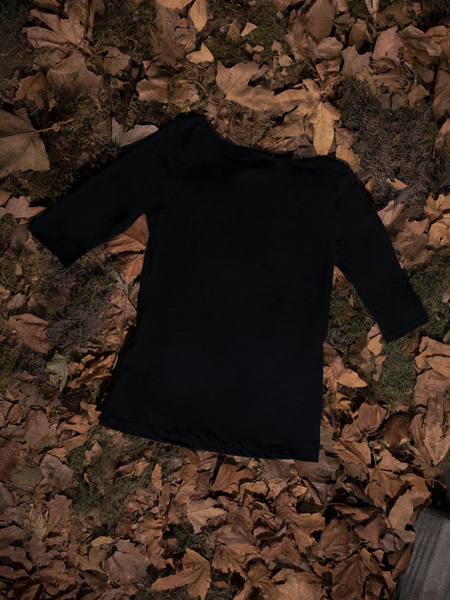 The back of the Sleepy Hollow™ Carved Pumpkin 3/4 Sleeve Tee laid out on a bed of leaves.