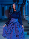 Female model wearing the Salem Top in Navy with a similarly colored skirt to pull off a goth glamour look. 
