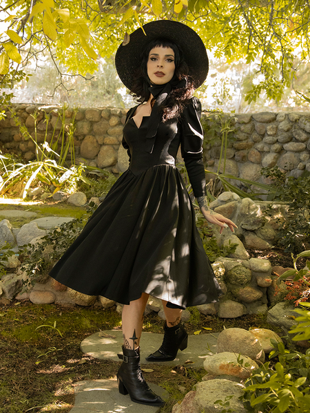 Caught mid-strut, Stephanie wears the all new Cottage Witch Dress in Japanese Black Satin from gothic retro clothing company La Femme en Noir.