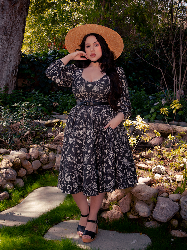 Within the ethereal forest realm, a breathtaking dark-haired beauty graces the scene, adorned in the enigmatic Dark Forest Dress, a gothic masterpiece crafted by the renowned La Femme en Noir.