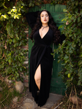 Rachel Sedory looking directly into the camera while wearing the Crawford Hostess Wrap Gown in Black.
