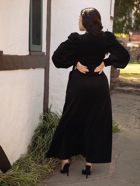 Rachel Sedory facing away from the camera to show off the backside of the black goth gown she's wearing from gothic clothing house La Femme en Noir.